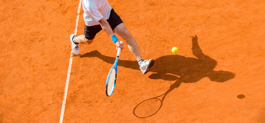 Old male tennis player in action on the court on a sunny day
