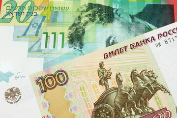 A macro image of a Russian one hundred ruble note paired up with a green and white twenty shekel bill from Israel.  Shot close up in macro.