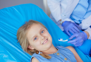 Little girl sitting in the dentists office.