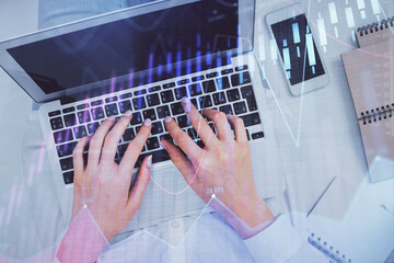 Double exposure of woman hands working on computer and forex chart hologram drawing. Top View. Financial analysis concept.