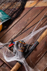 Fishing tacles on wooden background in Halloween designe with spaders and web