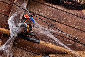 Fishing tacles on wooden background in Halloween designe with spaders and web