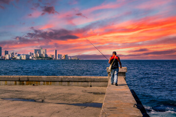 A fisherman during the sunset at El Malecon, La Havana