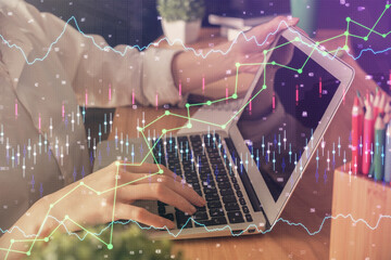 Double exposure of woman hands typing on computer and forex chart hologram drawing. Stock market invest concept.