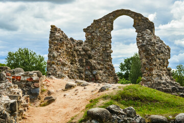 Old historic stone ruins of an ancient castle with a cloudy sky behind. Rezekne, Latvia.