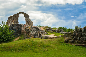 Old historic stone ruins of an ancient castle with a cloudy sky behind. Rezekne, Latvia.
