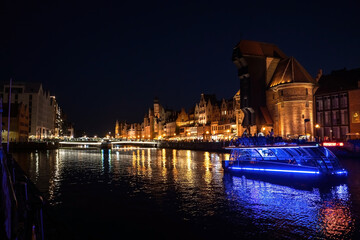 Fototapeta premium Gdansk, North Poland - August 15, 2020: Wide angle panoramic Night photography of polish cityscape with polish architecture in the old town over motlawa river near baltic sea