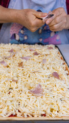 elderly woman white mother cutting sausages and sausages to make pizza