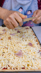 elderly woman white mother cutting sausages and sausages to make pizza