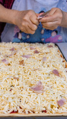 elderly woman white mother cutting sausages and sausages to make pizza