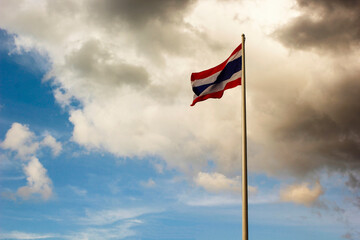 Thai flag fluttering in the sky with rain clouds.