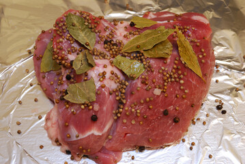 Piece of fresh pork meat with spices close up.