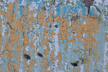 Peeling paint on the wall. Old concrete wall with cracked flaking paint. Weathered rough painted surface with patterns of cracks and peeling. High resolution texture for background and design. Closeup