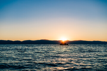 Sunset or Sunrise over Mountain Lake with Warm Light and Cool Water