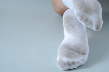 Fototapeta na wymiar Pair of child feet in dirty stained white socks. dirty socks 
