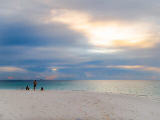 People on a sandy island at sunset in the Indian ocean near the Maldives