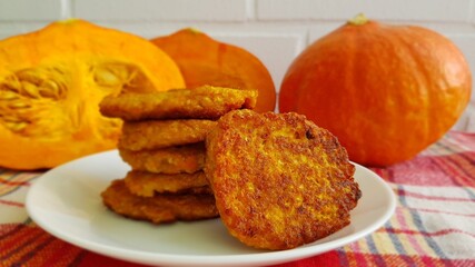 Pumpkin cutlets on a background of three pumpkins and a white wall