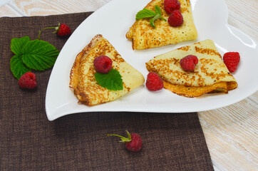 Close-up of delicious and mouth-watering homemade pancakes on a ceramic plate top view. Cooking and home baking in the bakery