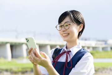 スマートフォンを触る女子高生