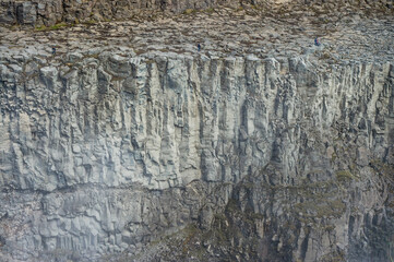 Man walking on a rocky path to Dettifoss waterfall in Iceland.