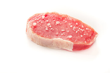 Piece of raw pork meat with salt isolated on white background. Side view