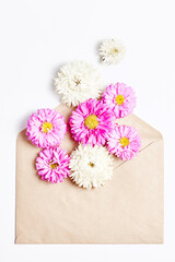 floral concept. invitation message in a craft envelope with flowers on a white background. simple flat layout