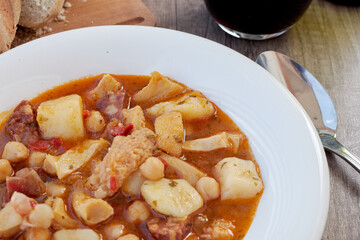 Mondongo a la espanola or cayos a la espanola. Presented on a white plate, on a wooden table Top view. View at 45 degrees. Foreground,