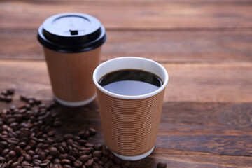 紙コップに淹れたホットコーヒーとコーヒー豆