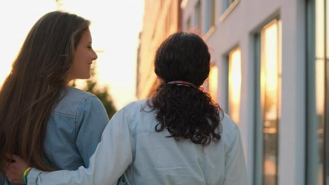 Two lesbian woman lgbt couple hugging, kissing, hands with rainbow symbol outdoors. Gay, bisexual, transgender movements. Concept of LGBT happiness, freedom, love same-sex couple, 4 K slow-mo