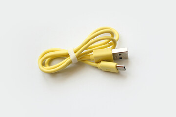 yellow USB cable on white background. USB and USB-mini cable connectors close-up. A patch cable or patch cord or patch lead.