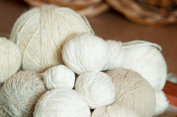 many balls of light wool threads of different sizes and shades, knitting materials