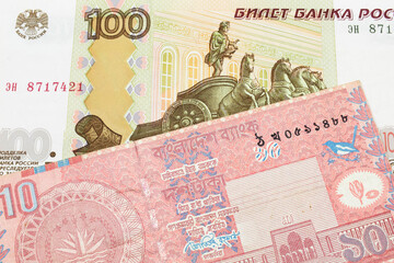 A macro image of a Russian one hundred ruble note paired up with a red ten taka bank note from Bangladesh.  Shot close up in macro.