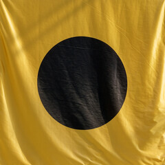 Black circle on yellow cloth.
