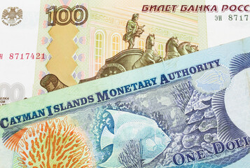 A macro image of a Russian one hundred ruble note paired up with a colorful one dollar note from the Cayman Islands.  Shot close up in macro.