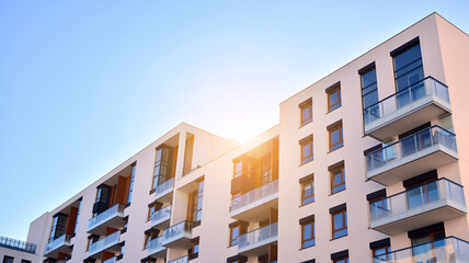Modern apartment buildings on a sunny day with a blue sky. Facade of a modern apartment building. Glass surface with sunlight.