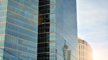 Office building, details of blue glass wall and sun reflections.