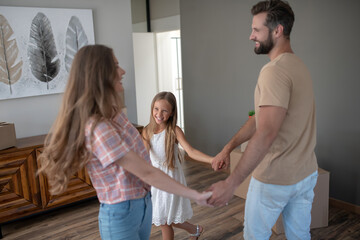 Mom, dad and kid dancing in the room