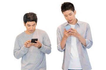 Two cheerful friends wear gray t-shirts standing isolated over white background, holding mobile phone.Couple of cool guys using smartphone