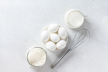 Pancakes ingredients. Flour, egg, milk on a table, view from above