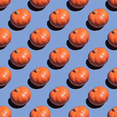 Trandly sunlight pattern made with orange pumpkin on violet background. Harvest and Thanksgiving theme. Good for wallpaper, textile, background, poster, cover of book, post card.