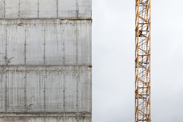 Tower crane fragment near concrete wall