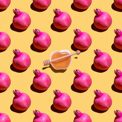 Rosh Hashanah seamless pattern made with pomegranate fruit and fresh honey on yellow background. Minimal concept. Good for wallpaper, textile background, poster, cover of book, post card.