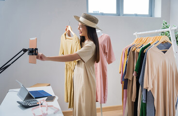 Asian woman selling vintage clothes, she is live on social media..She is answering customers...