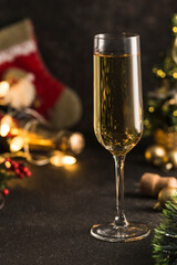 New year 2021-a glass of champagne on a dark background with a bokeh of garlands.