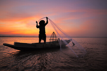 Asian fisherman with his wooden boat in nature river at the early morning before sunrise