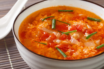 Easy Tomato Egg Drop Soup or egg flower soup close-up in a bowl on the table. Horizontal