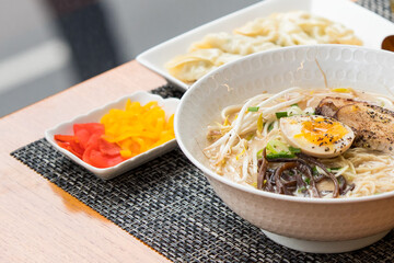 Close up image of Japanese style ramen noodle with soft boiled egg and pickle side dish