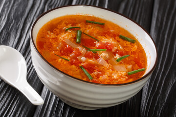 tomato drop egg soup close-up in a bowl on the table. horizontal