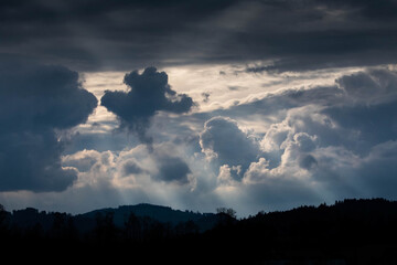 Sonnenstrahlen die durch die Wolken strahlen und eine mystische Stimmung am Horizont erzeugen