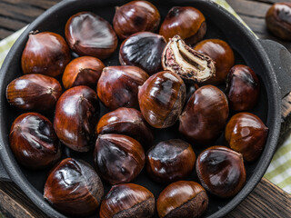 Roasted edible chestnut fruits in the pan. Top view.